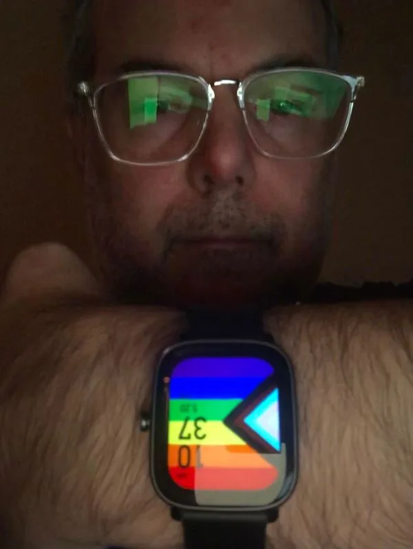 Person showing pride flag on smart watch face